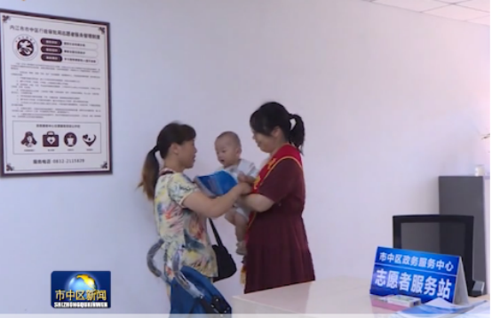 3.行政审批局政务服务大厅志愿者为办事群众照顾小孩，方便其办理业务.jpg